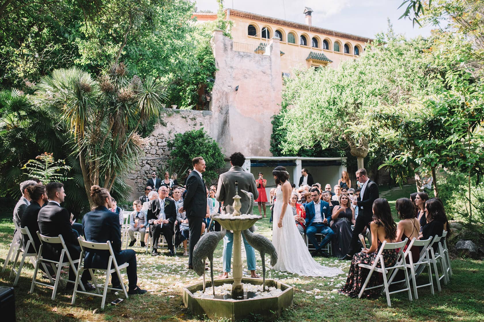 Destination wedding at Villa Almanita, Sitges: Clara and Toph exchange vows outdoors. - Barcelona Wedding Photographer