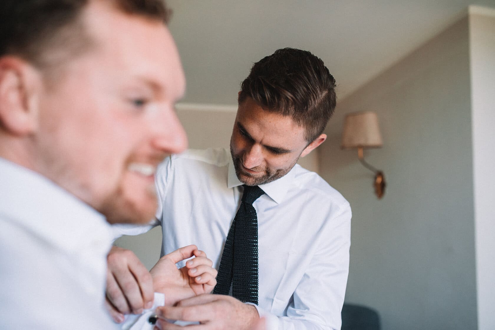 Groom getting ready with help from best man at destination wedding villa - Barcelona Wedding Photographer