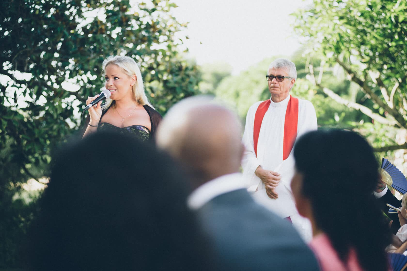 Wedding photographer capturing a bride speaking into a microphone at an outdoor ceremony in S'Agaro, Spain. - Barcelona Wedding Photographer