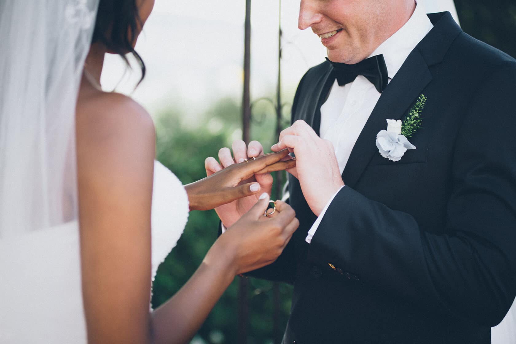 Groom places wedding ring on bride's finger during ceremony, Tsega & Anders wedding photographer S'Agaro Spain - Barcelona Wedding Photographer