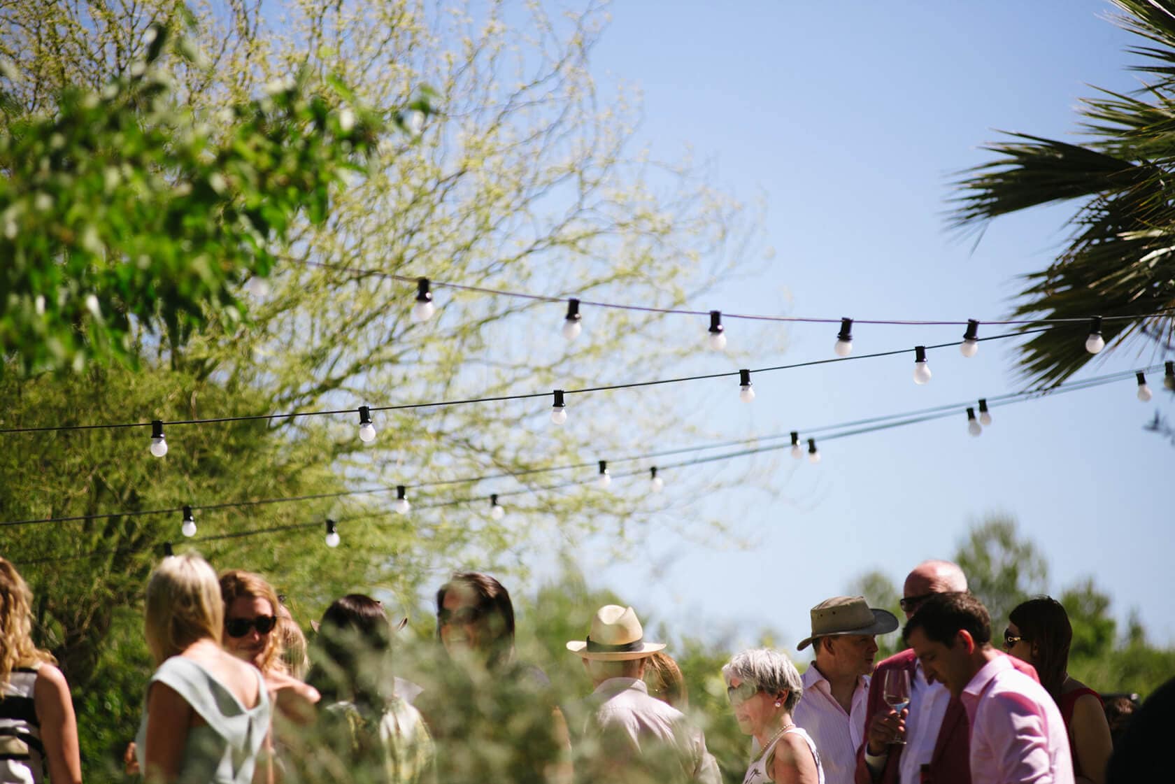 Guests mingle outdoors at Casanova Estate wedding venue under string lights. - Barcelona Wedding Photographer
