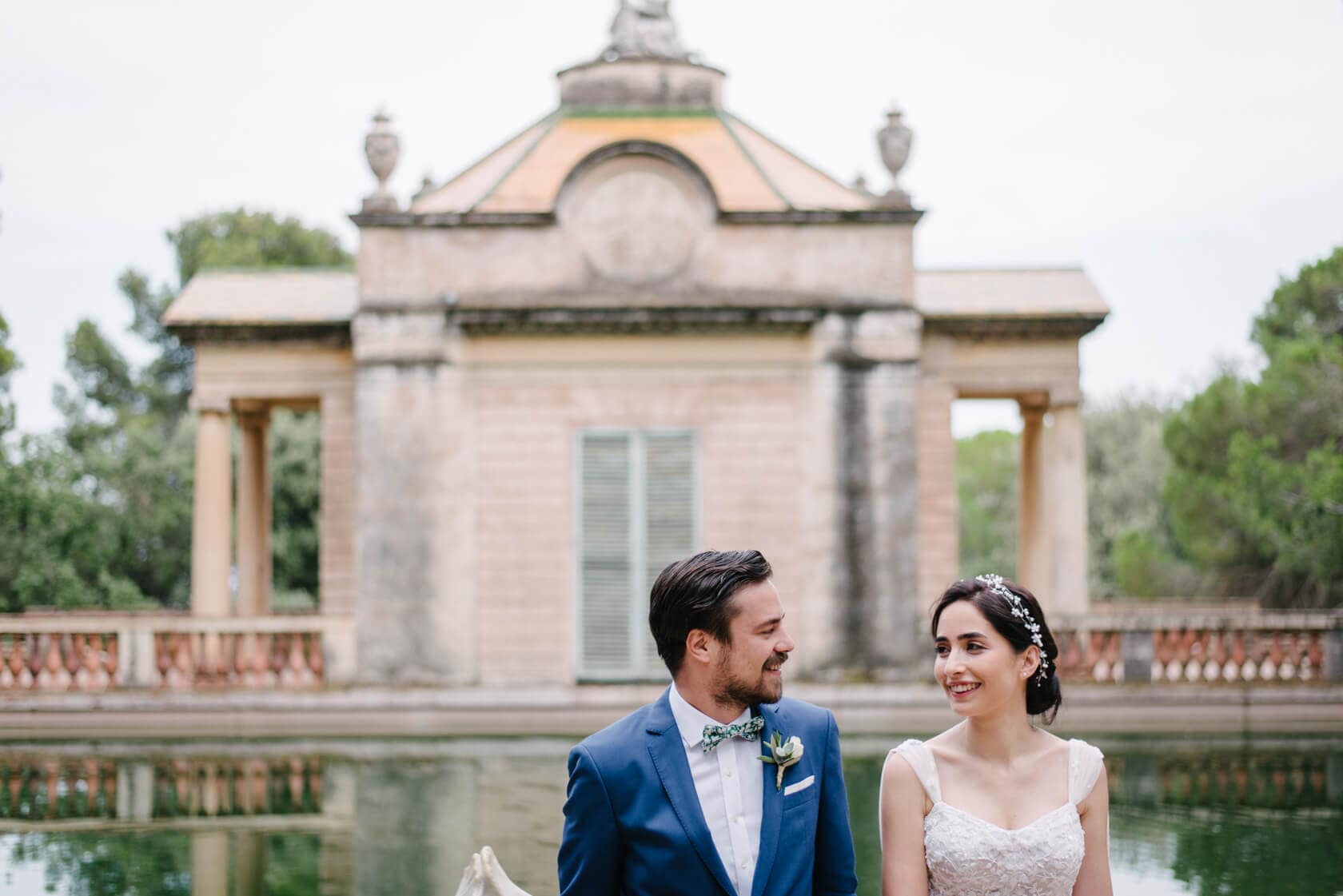 Wedding couple at Parc del Laberint d'Horta with building and pond - Barcelona Wedding Photographer
