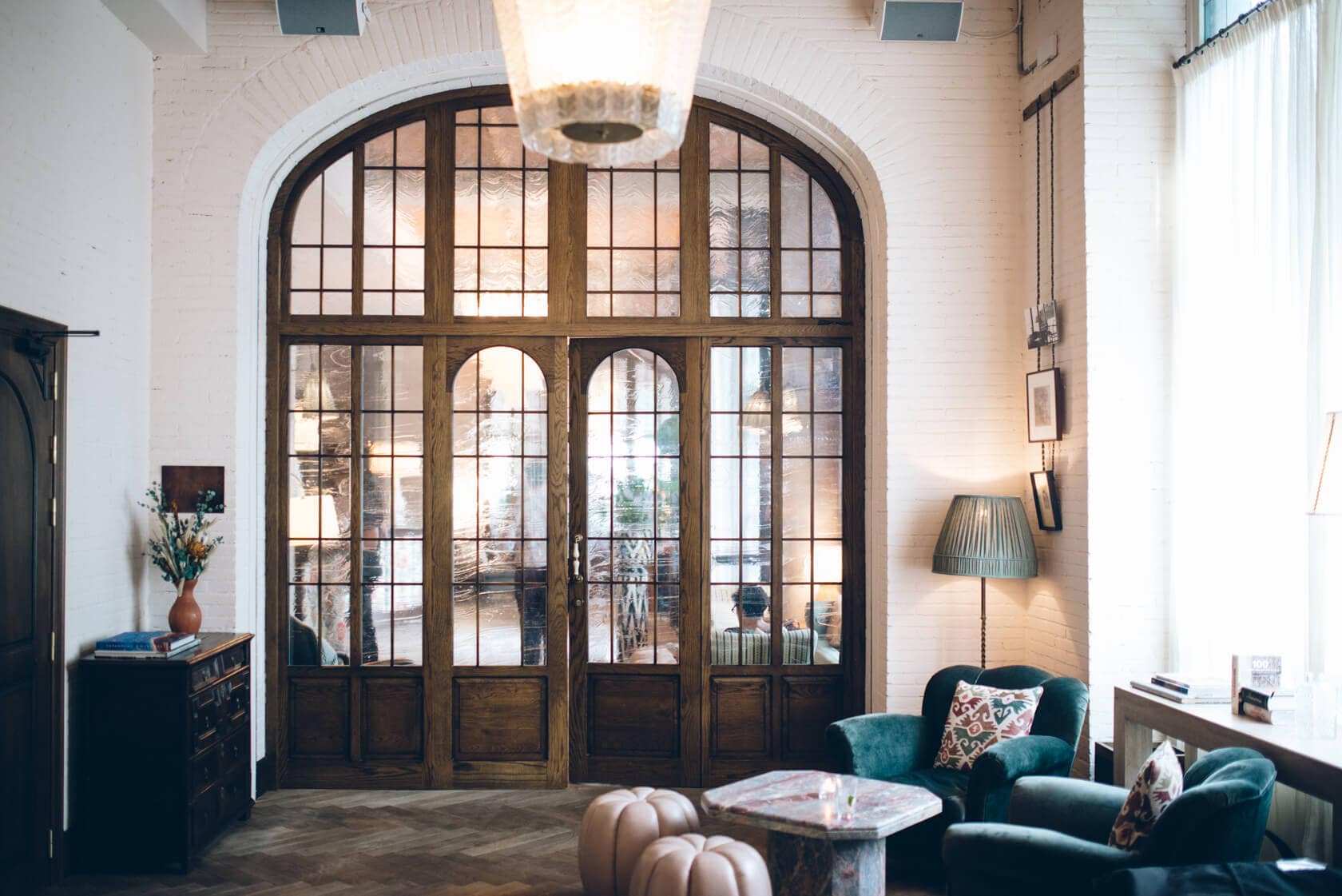Elegant arched doorway with wooden panels and glass, leading to a wedding venue. - Barcelona Wedding Photographer