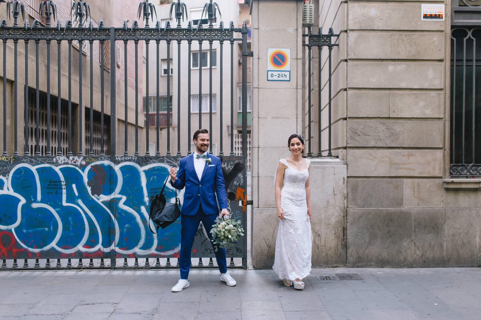 Bride and groom pose for wedding photo in front of graffiti wall near Parc del Laberint d'Horta - Barcelona Wedding Photographer