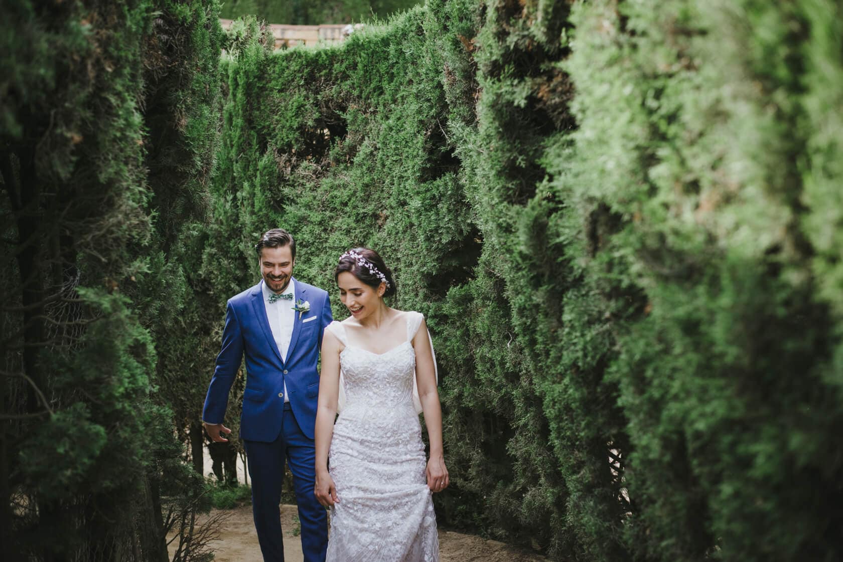 Bride and groom walking through cypress trees at Parc del Laberint d'Horta wedding. - Barcelona Wedding Photographer