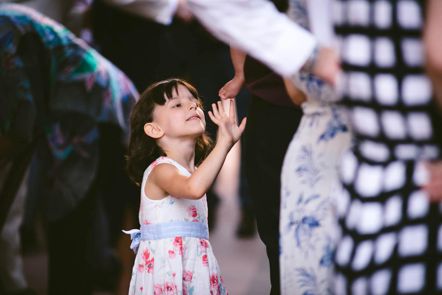 Little girl in floral dress reaching for baby at vintage style wedding - Barcelona Wedding Photographer