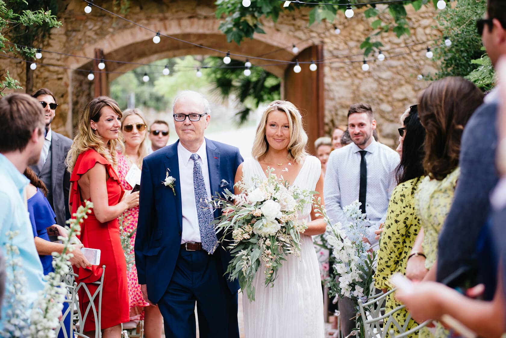 Hayley and Mark, a bride and groom, walk hand-in-hand at their wedding. - Barcelona Wedding Photographer
