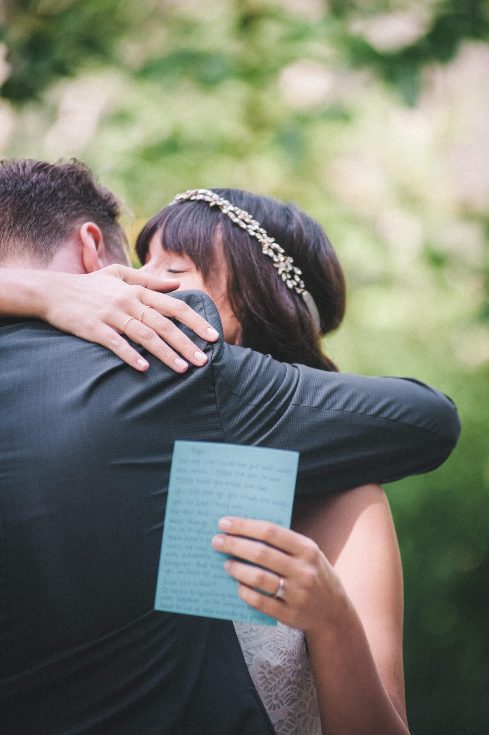 Bride hugs groom at destination wedding villa in Sitges, holding vows - Barcelona Wedding Photographer