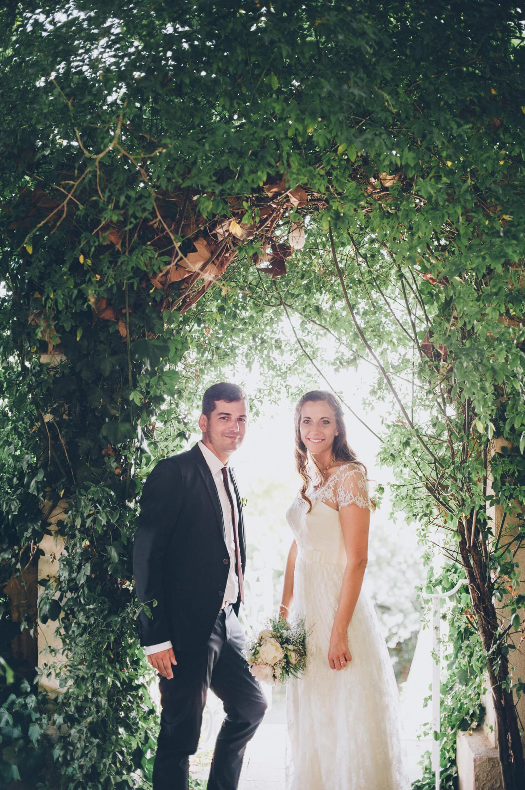 Cris and Rafa wedding portrait under lush green archway, Barcelona wedding photographer - Barcelona Wedding Photographer
