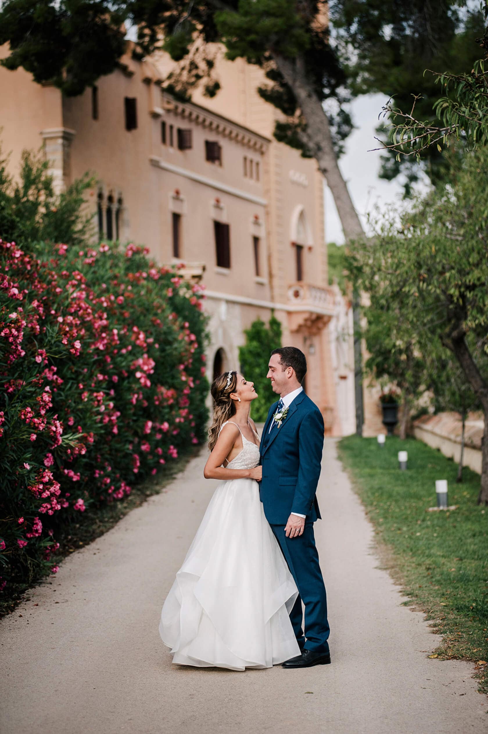 Hayley and Mark, a bride and groom, walk hand-in-hand at their wedding. - Barcelona Wedding Photographer