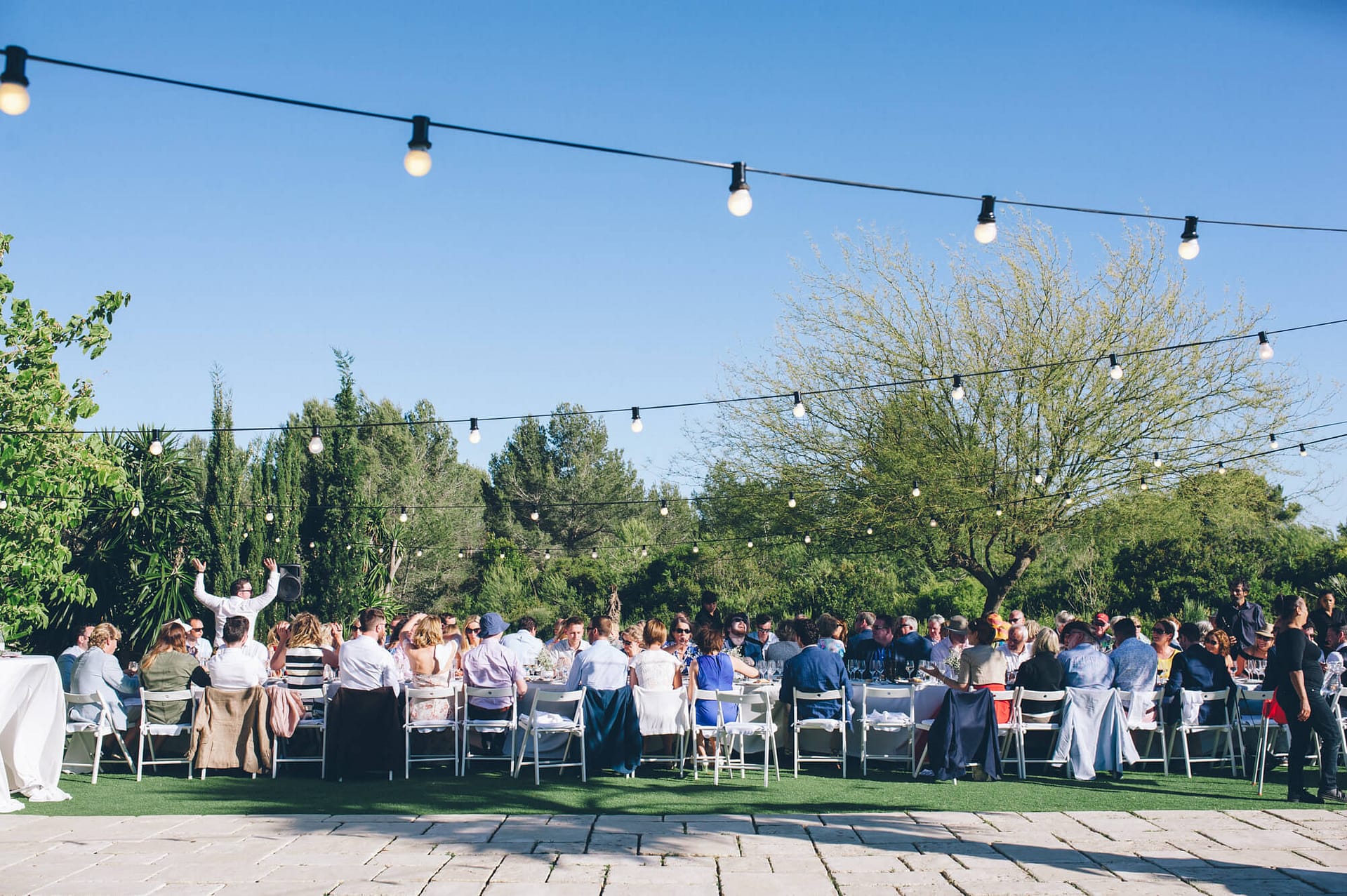 Outdoor wedding reception at Casanova Estate with guests seated at long tables. - Barcelona Wedding Photographer